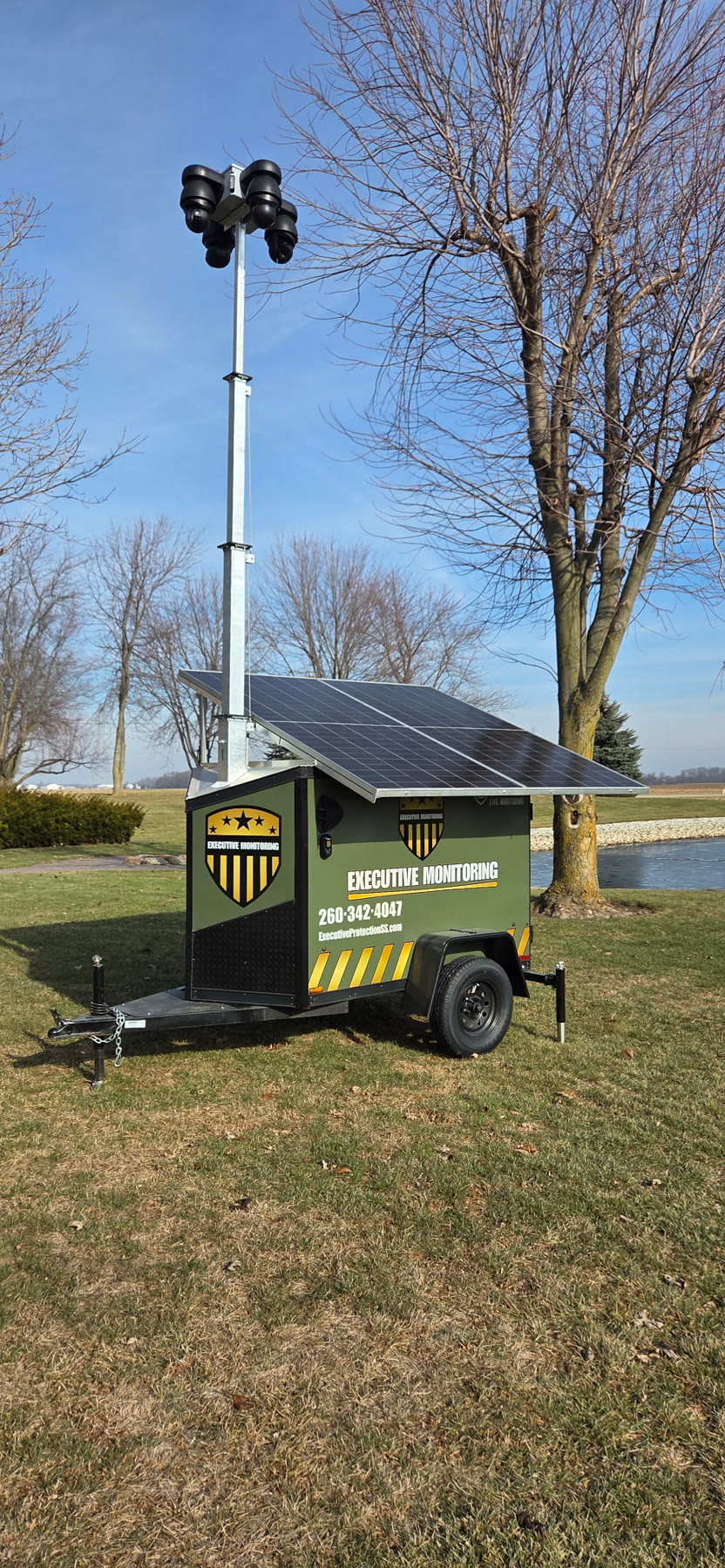 Executive Monitoring solar surveillance trailer deployed in an open field with camera mast raised