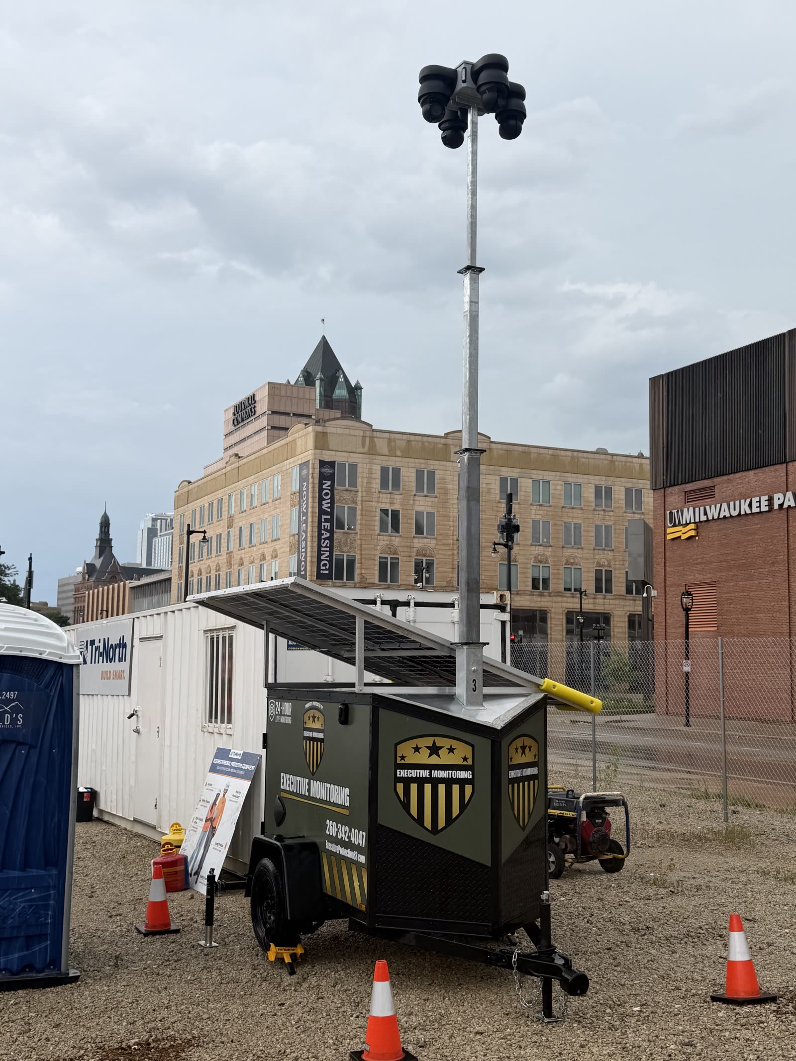 Executive Monitoring surveillance trailer deployed on an active Tri-North construction site in downtown Milwaukee, camera mast fully raised