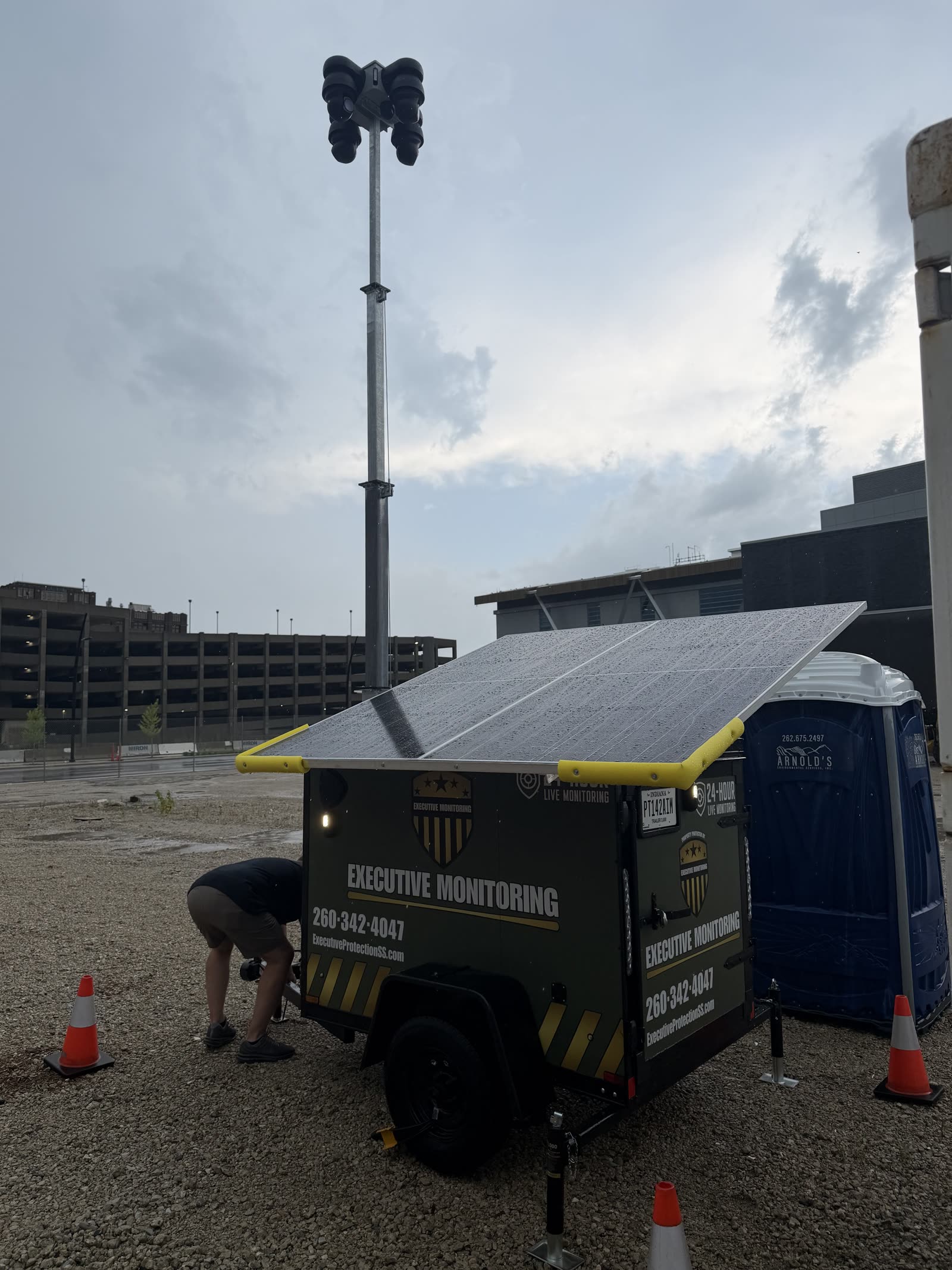 Close view of an Executive Monitoring trailer's solar panels and 360-degree camera head on an urban construction site
